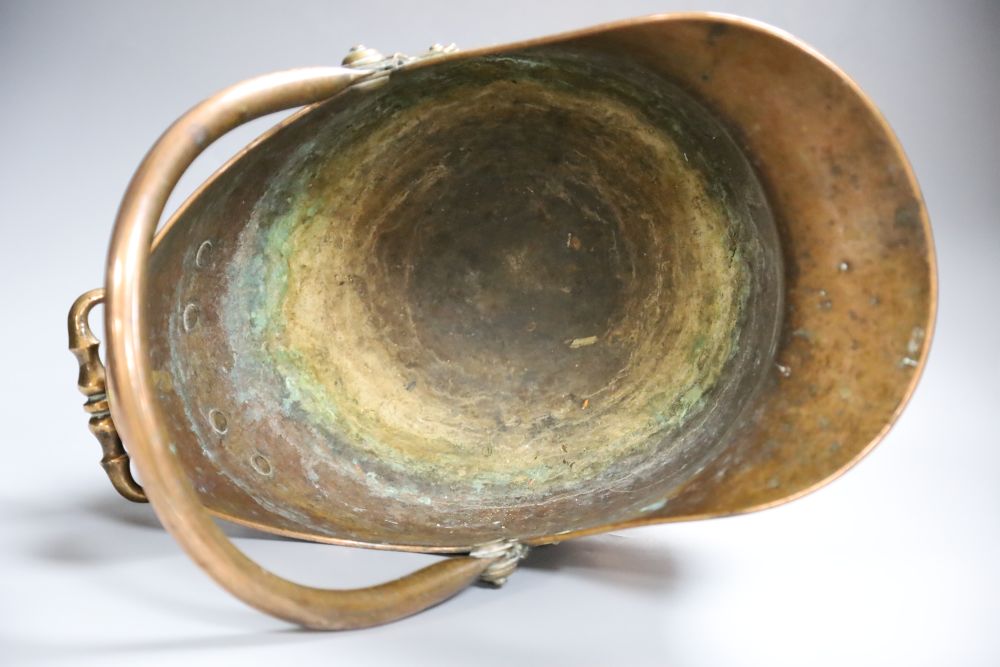 A 19th century planished copper helmet coal scuttle